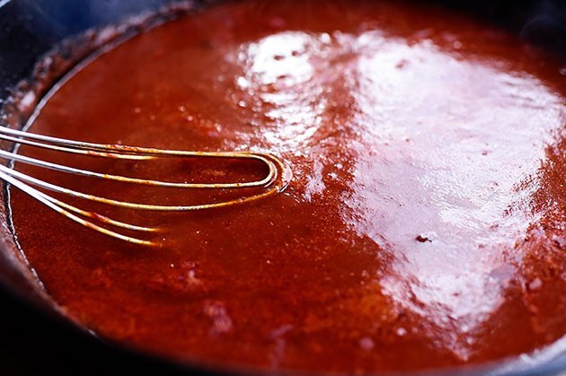 خفق صلصة الطماطم والماء الساخن (بالإضافة إلى الصلصة الحارة) وضعيها لتغلي مع خفض الحرارة و أضيفي الملح والتوابل.